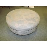 A modern circular footstool on beech sup