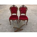 A pair of chairs with red velvet upholst