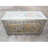 A wooden chest with brass classical pane