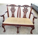 A two seater, intricately carved framed