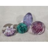 Four glass paperweights of which three a