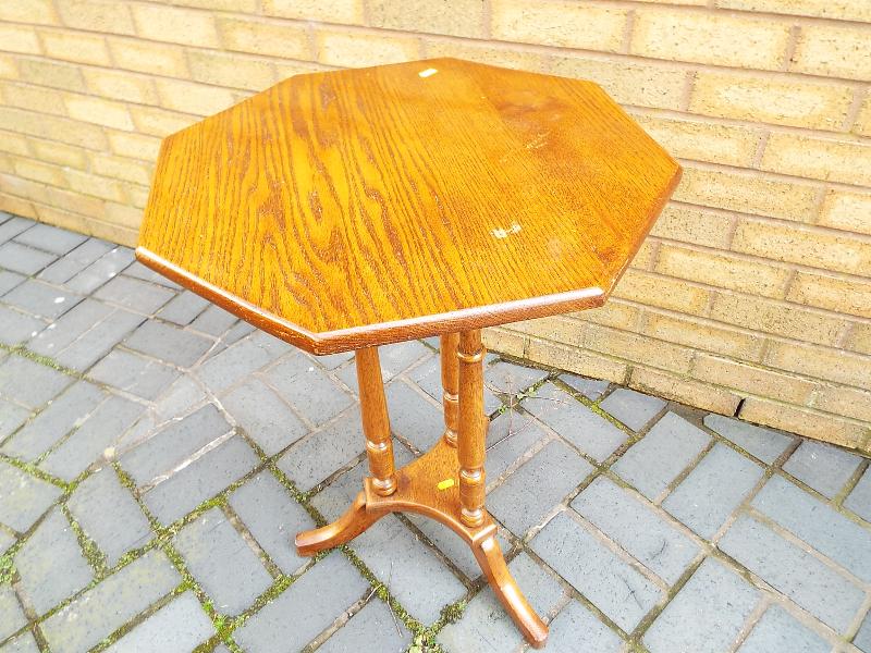 An octagonal topped oak table on tripod