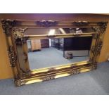 A large mirror with gold frame and brass