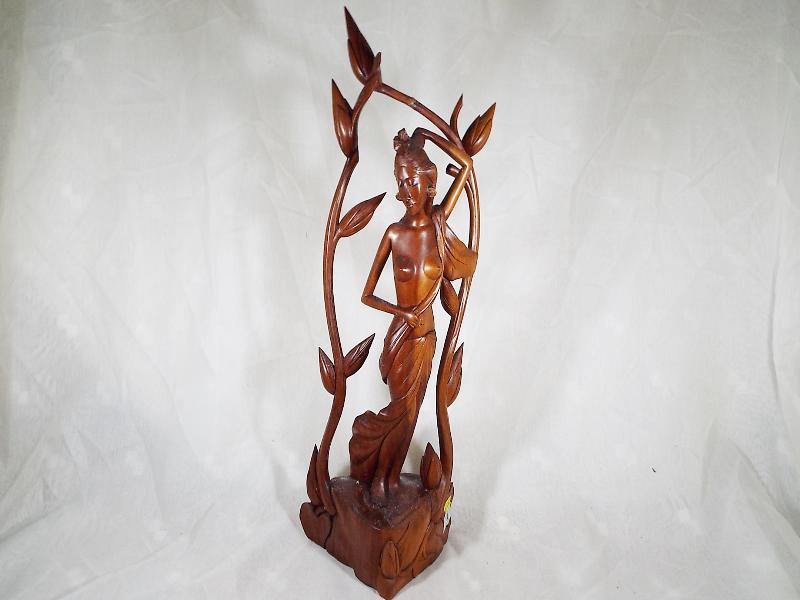 A carved wooden figurine depicting a nud