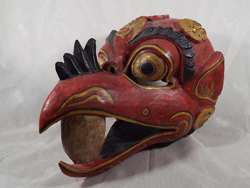 A carved wooden wall mask depicting the