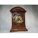 A carved oak mantel clock with pendulum