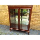 A good quality mahogany display cabinet on cabriole feet, the two bevelled glazed doors opening to