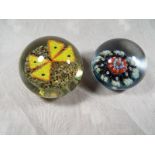 Two glass domed paperweights comprising