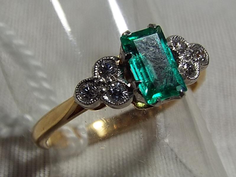 A lady's 14 carat gold and platinum ring, with diamond set in trefoil formation and emerald,