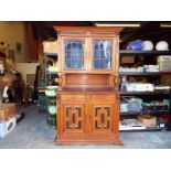 A good oak sideboard with storage space above with two leaded glass doors, carved lions heads