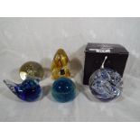 A collection of art glass paperweights to include two Langham weights, one with box, a blue and