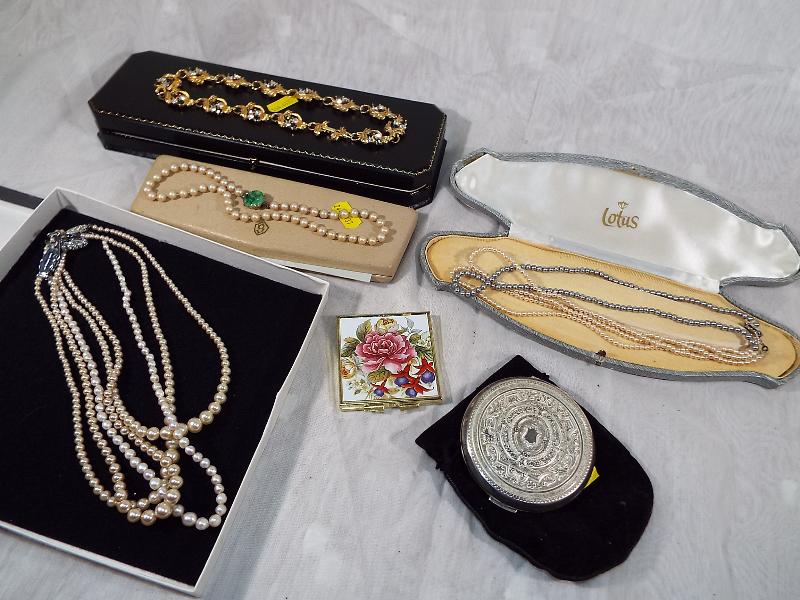 A Stratton powder compact, a small compact mirror and a collection of pearl necklaces and similar
