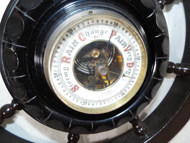 A wall mounted aneroid barometer in the form of a ships wheel, white enamel dial with open centre - Image 3 of 3
