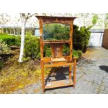 An Art Nouveau oak mirror back hall stand with central shelf and opening storage box, coat hooks