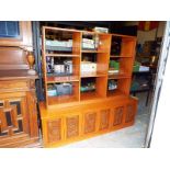 A bookcase, the storage compartment below with carved front doors, decorated in an Oriental style,