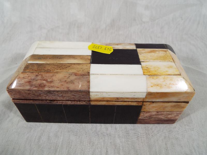 An unusual inlaid small wooden hinge lidded box containing a collection of costume jewellery to
