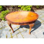 A mahogany oval table with cabriole supports