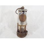 A miner's brass safety lamp marked Protector Lamp & Lighting Type GR6S 38 Eccles, approximately
