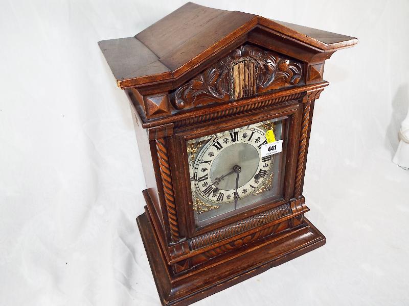 A bracket style mantel clock, the hour and half past gong strike movement by Jughans, the carved