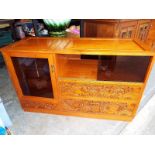 A rectangular cabinet with carved front decorated in an Oriental style, 72cm (h) x 117cm (w) x 46cm