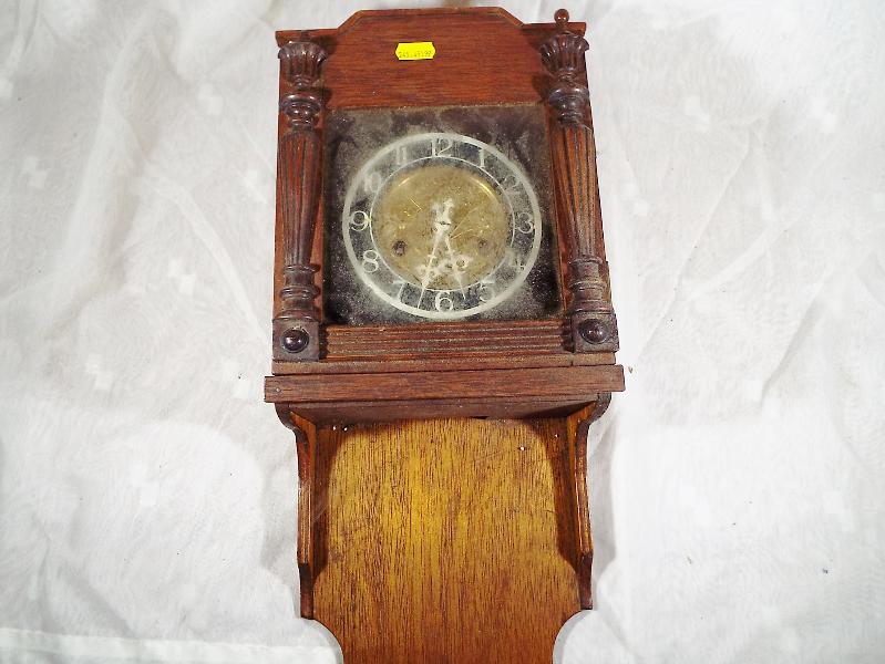 A wall clock with square brass dial and turned decoration to the wooden case Est £10 - £15