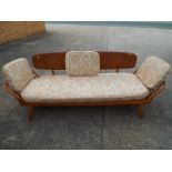 An Ercol light elm and beech three-seater sofa / day bed designed by Lucian R Ercolani classic