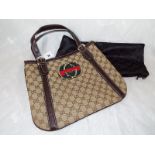 A lady's genuine Gucci handbag bearing logo's and zipped pockets with protective dust cover