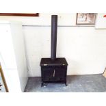 A Delamere cast iron multi-fuel log burner with pipe, nominal use Est £100 - £150