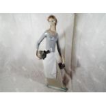 A large Nao figurine depicting a lady holding a water carrier, 40cm (h) Est £20 - £30