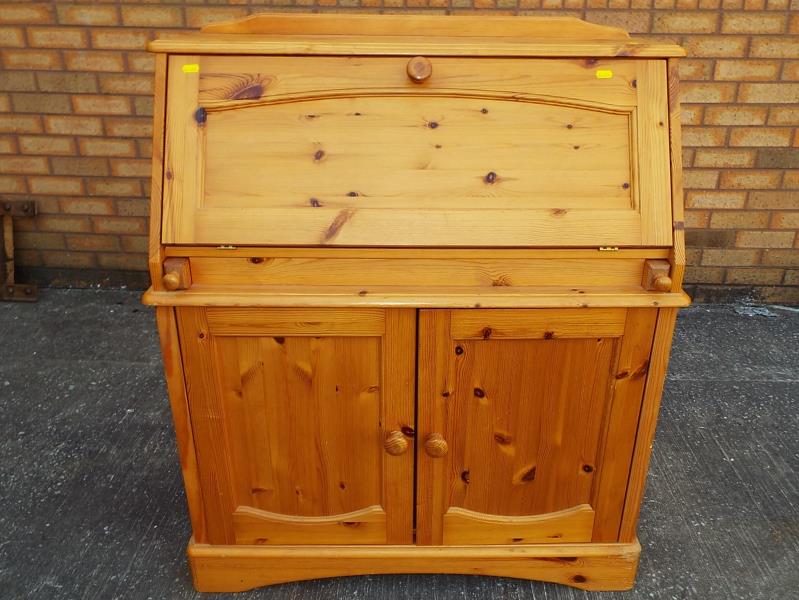 A good modern pine writing bureau with slope front opening to reveal a fitted pigeon-hole interior,