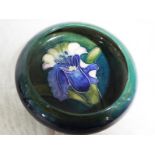 A Moorcroft pottery small pedestal bowl with inverted rim decorated with orchids on a green ground,