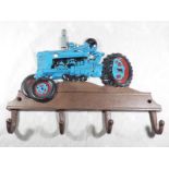 A wall-mounted cast iron novelty coat hanger decorated with a depiction of a farm tractor, 28 cm x