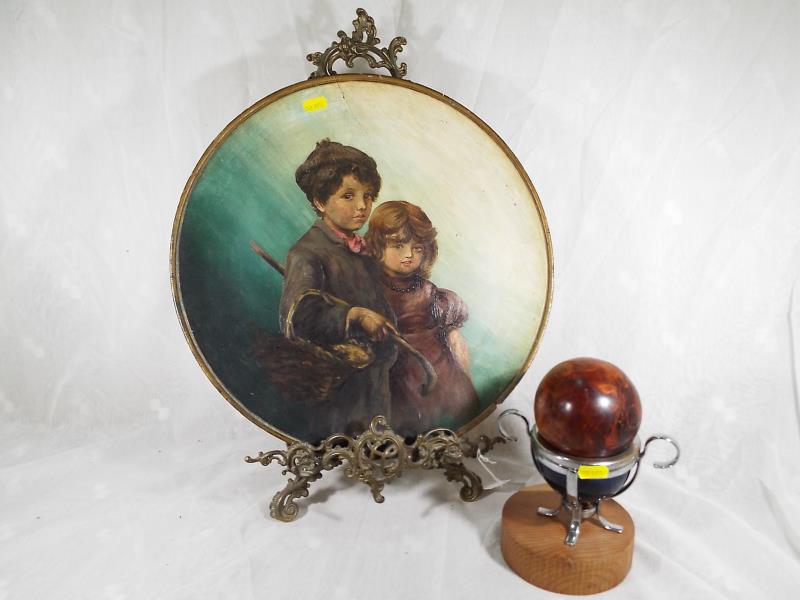 An oil painting on a large wooden plaque depicting a boy and girl in vintage costume, 40cm (diam)