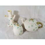 Three pieces of Belleek decorated with depictions of shamrocks, comprising a lidded teapot, lidded