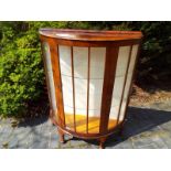 A bow-fronted mahogany display cabinet, the front opening to reveal a glass shelved interior, with