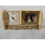 A mid century musical alarm clock in the form of a television console, one half of has a white dial