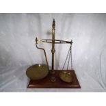 A brass weighing scale on wooden plinth, inscribed Agate Balance Piper & Co, with weights