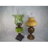 A pair of oil lamps, one with a cast metal base, a two tone green glass oil font complete with