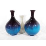 A pair of bulbous vases, decorated in shades of purple and blue, 23cm (h)