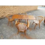 An Ercol light elm drop-leaf dining table, elm top, beech body and four Ercol dining chairs - Est