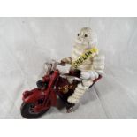 A cast iron novelty model depicting a Michelin Man mounted on a motorbike, 16 cm (high)