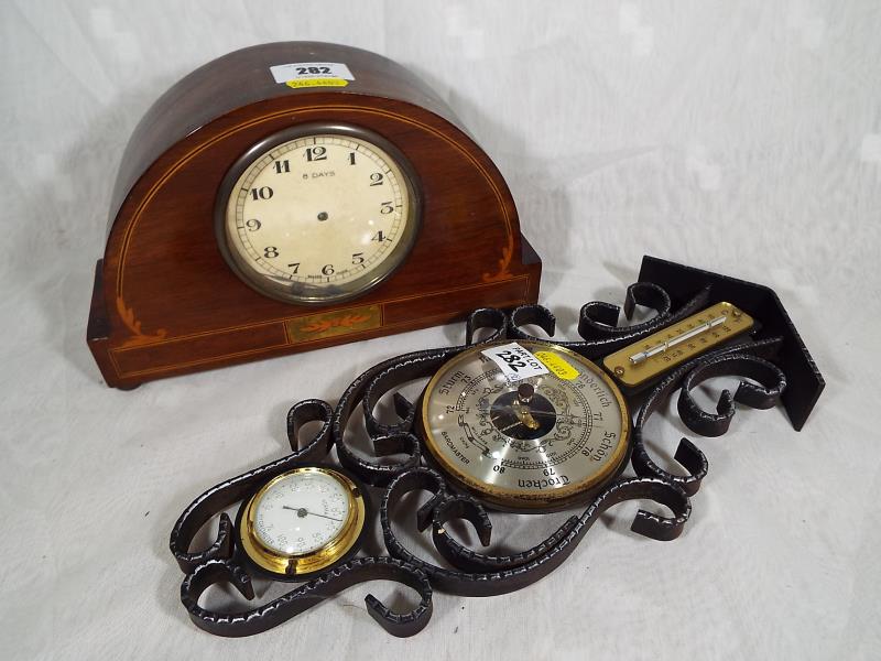 A A polished and inlaid wood cased wind-up mantel clock together with a decorative wall-mounted