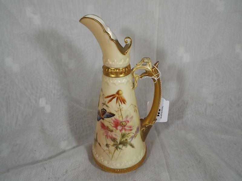 A late 19th century Royal Worcester ewer with gilt floral decoration depicting a butterfly on a