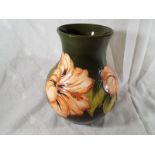 Moorcroft Pottery - A large vase decorated with pink coral hibiscus on a green ground, signed to