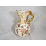 A late 19th century Royal Worcester water jug with gilt floral decoration on a blush ivory ground,