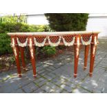 An ornate mahogany hall table on tapered supports decorated with swags and gilded highlights, 89 cm