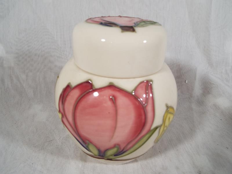 Moorcroft Pottery - A lidded ginger jar decorated with pink magnolia on an ivorine ground, 10.5cm