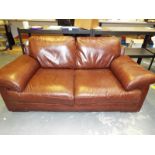A brown leather two seater sofa 85 cm x 185 cm x 98 cm