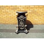 An ornate mahogany column with hand painted decoration depicting acanthus leaves and rams heads,