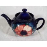 Moorcroft Pottery - A lidded teapot decorated with anemones on a cobalt blue ground - Est £100 -